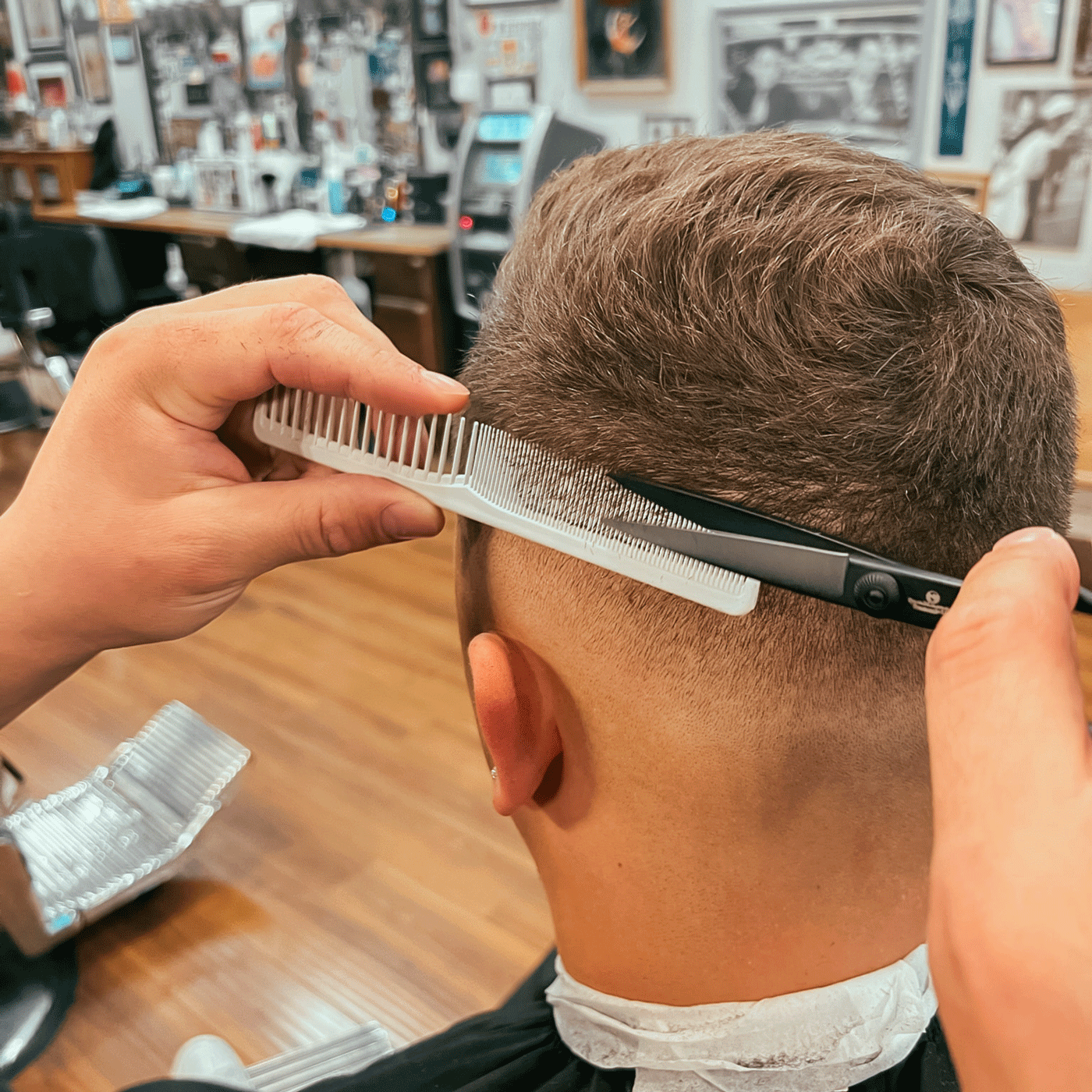 A skilled barber using high-quality products like the Styling Comb and Gentlemen Republic Scissors to achieve a premium look for discerning men.